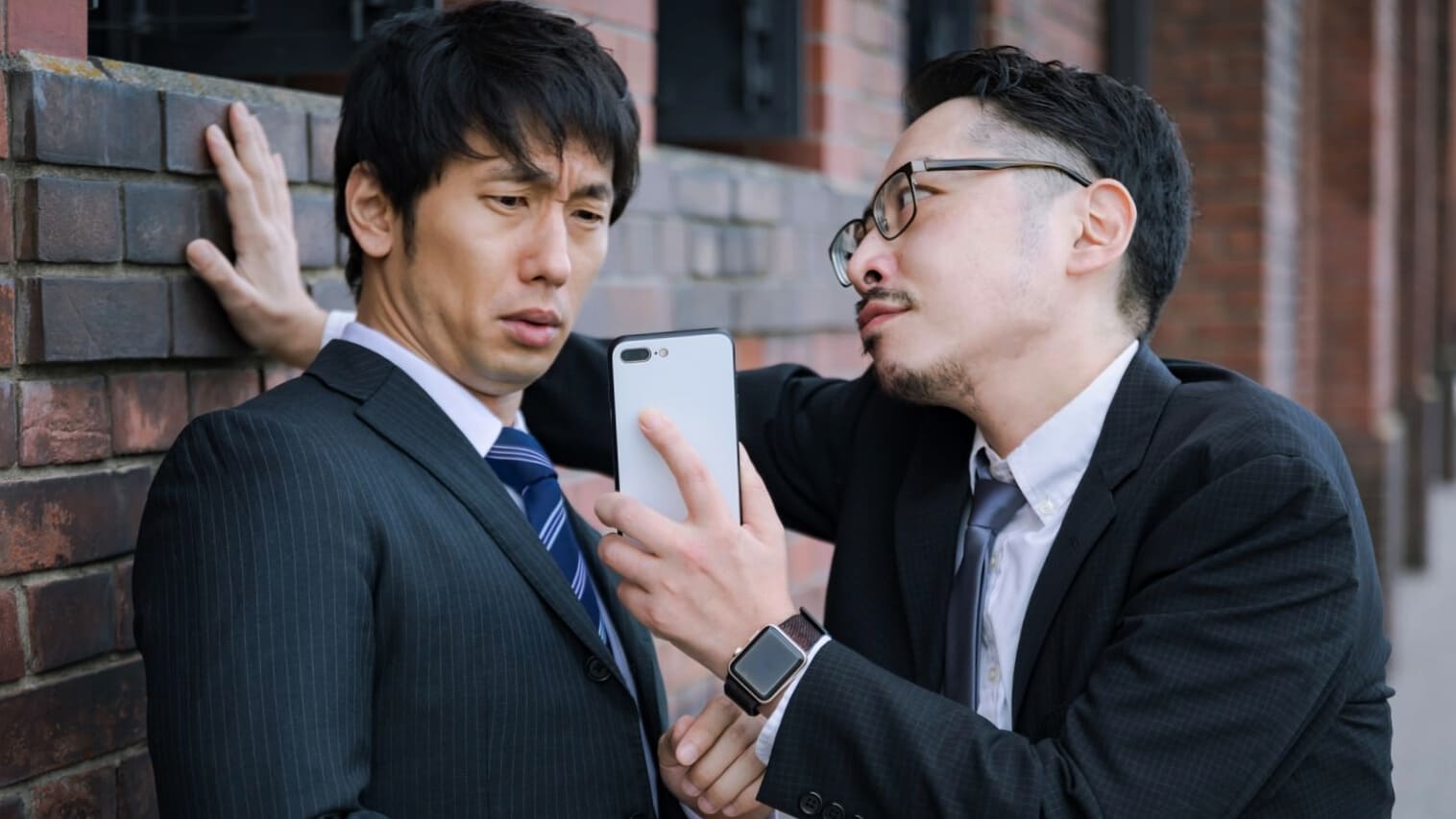 スマホを持ち詰め寄る上司と部下