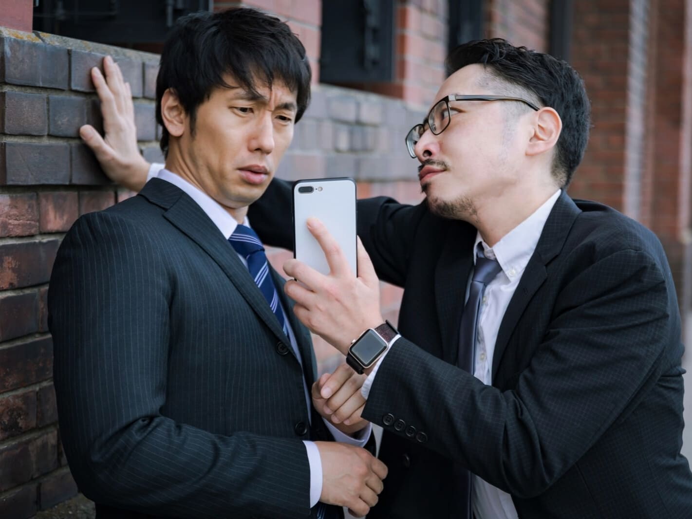 スマホを持ち詰め寄る上司と部下