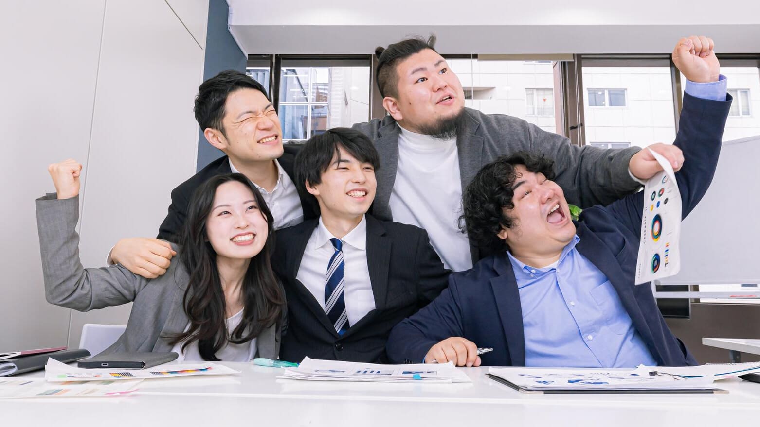 プロジェクト達成の喜びを分かち合う社内チーム