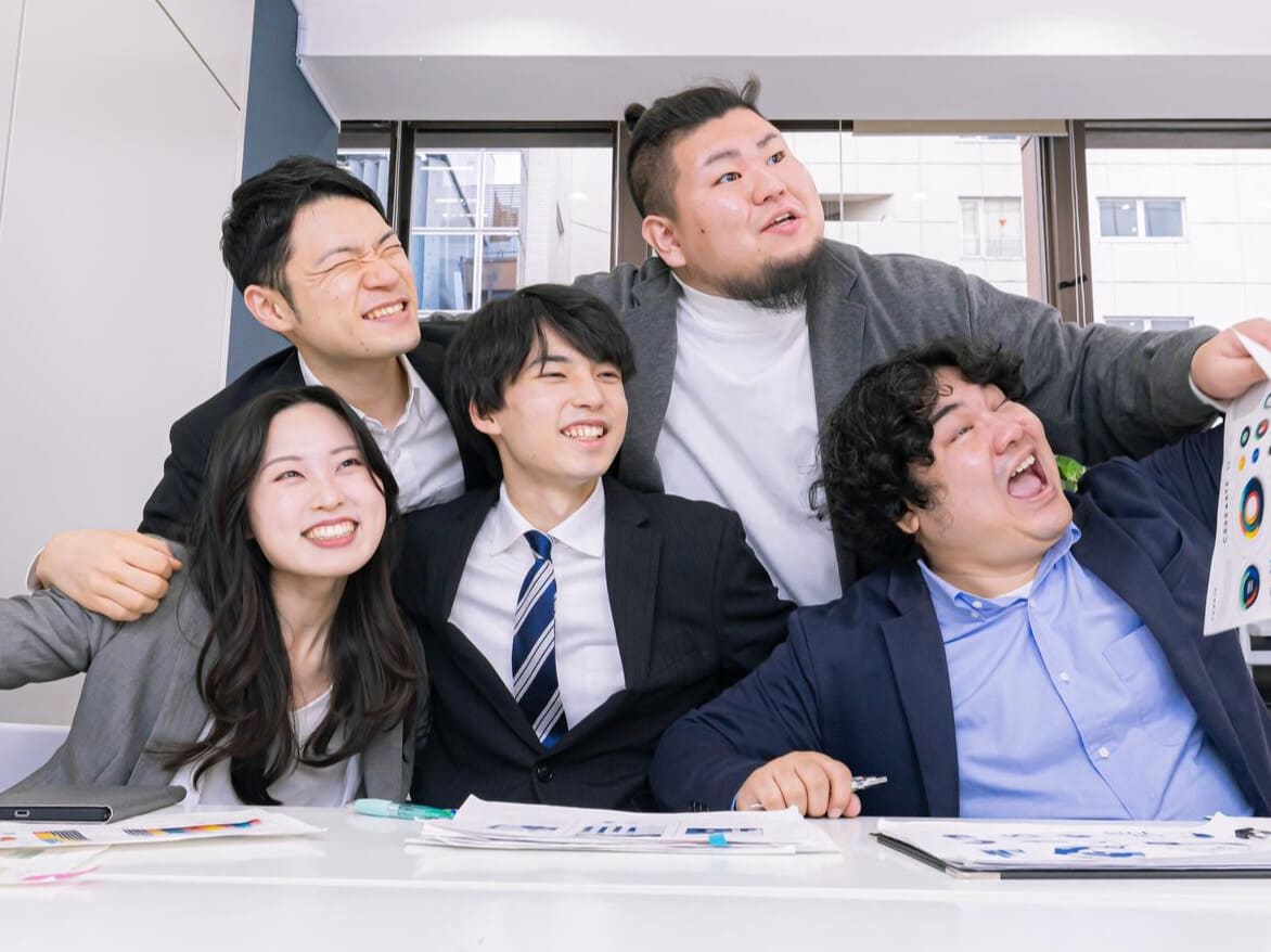 プロジェクト達成の喜びを分かち合う社内チーム
