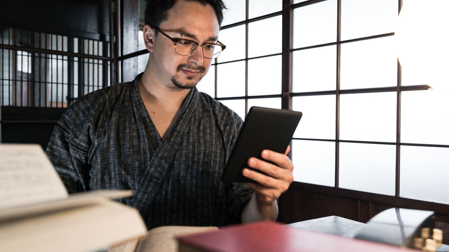 読書を止めスマホをいじるドイツ人ハーフ男性