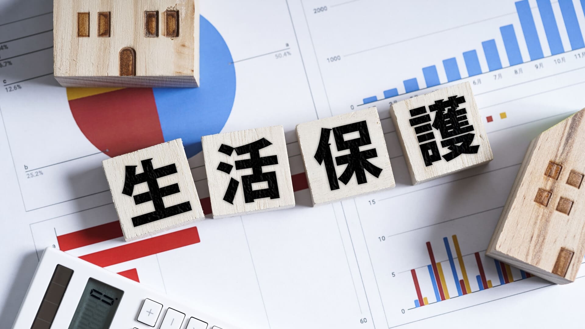 書類背景に積み木の生活保護の文字